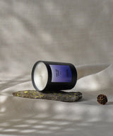 still life bougie sacré français parfum Oh My God avec motifs de pin sur fond beige